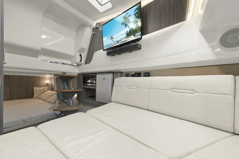  Yacht Photos Pics Luxurious interior of 2022 Sea Ray SLX 400 Outboard with sofa, bed, and TV.