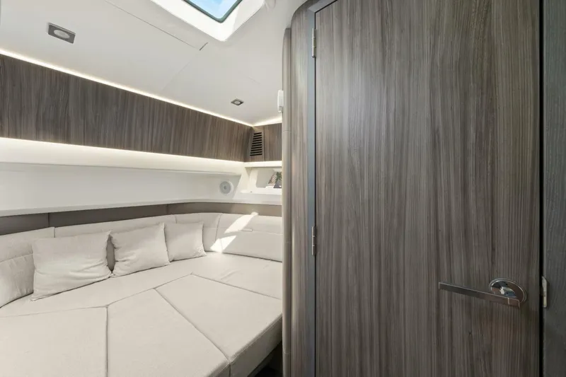  Yacht Photos Pics Interior cabin of 2022 Sea Ray SLX 400 Outboard, featuring modern wood paneling and cozy seating.