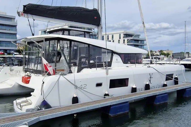  Yacht Photos Pics 2024 Lagoon 42 catamaran docked at marina, featuring modern design and spacious deck.