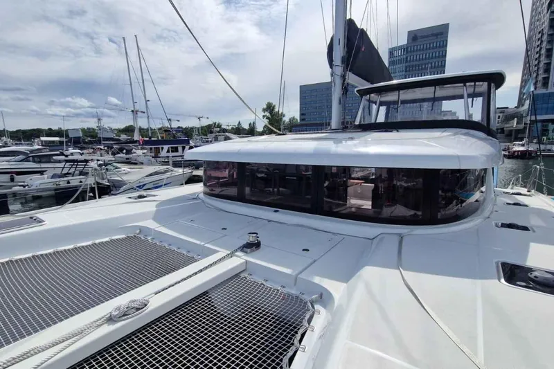 Yacht Photos Pics 2024 Lagoon 42 catamaran docked in marina, showcasing sleek design and spacious deck.