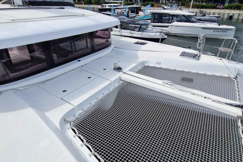  Yacht Photos Pics 2024 Lagoon 42 catamaran with spacious deck and netting, docked at marina.
