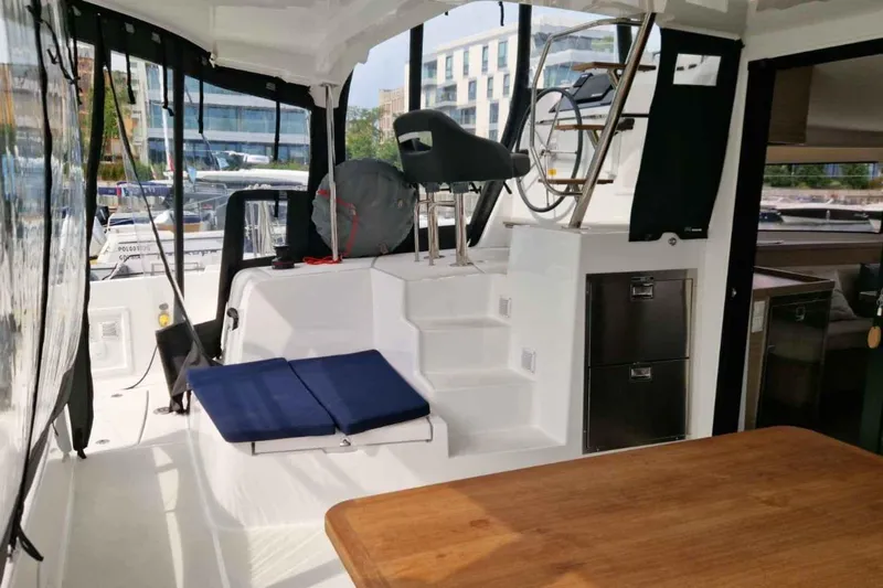  Yacht Photos Pics 2024 Lagoon 42 yacht cockpit with seating, steering wheel, and modern interior design.
