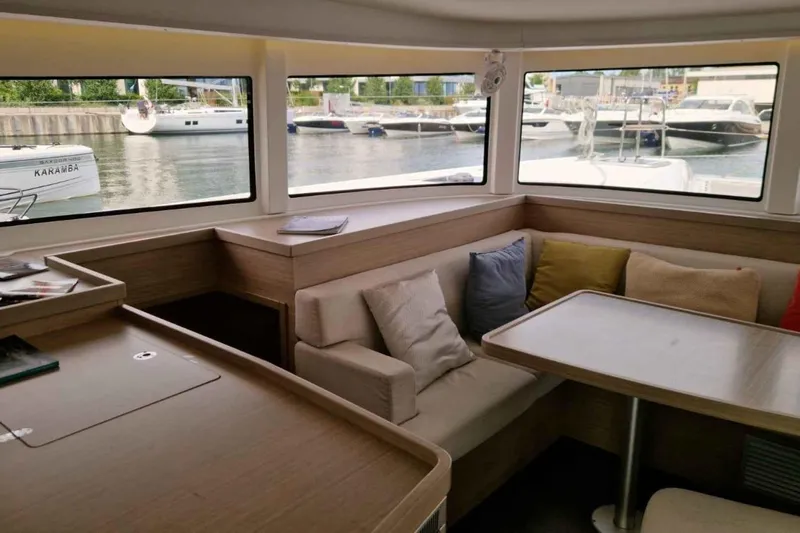  Yacht Photos Pics Interior of 2024 Lagoon 42 catamaran with cozy seating and large windows.