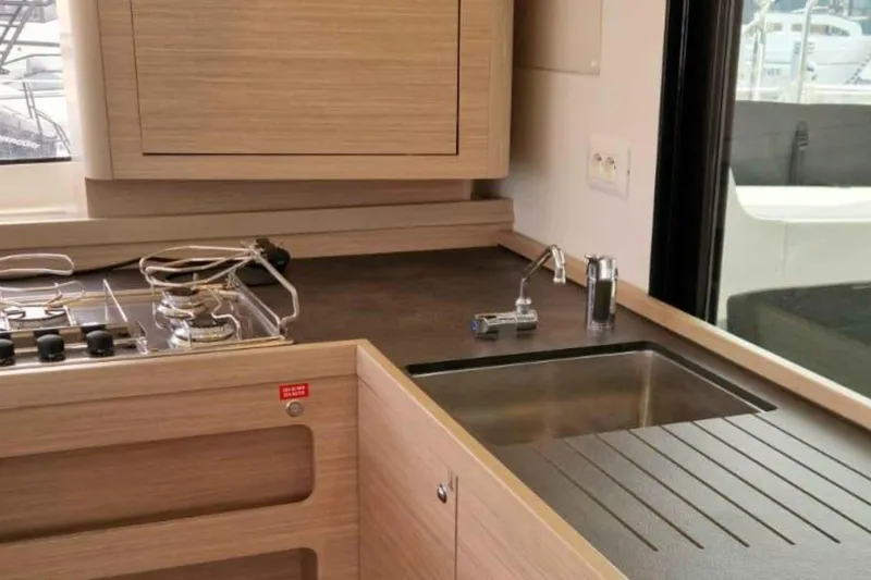  Yacht Photos Pics Modern kitchen interior of 2024 Lagoon 42 yacht with sleek design and appliances.