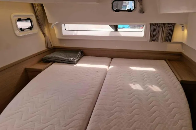  Yacht Photos Pics 2024 Lagoon 42 yacht cabin with twin beds, wooden accents, and natural light.