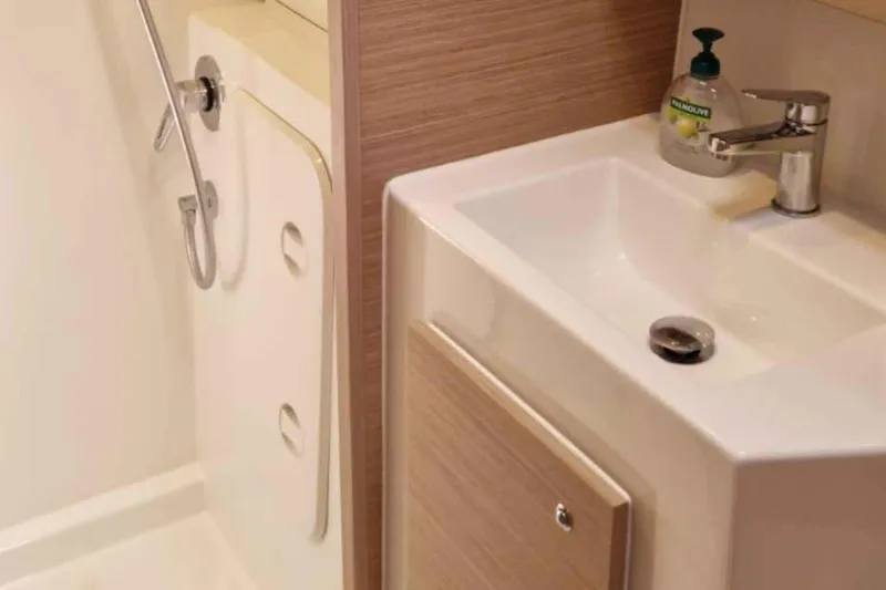  Yacht Photos Pics 2024 Lagoon 42 yacht bathroom with modern sink and shower.