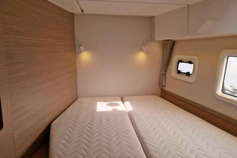  Yacht Photos Pics 2024 Lagoon 42 yacht cabin with twin beds, modern design, and natural light.