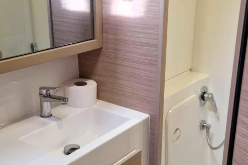  Yacht Photos Pics Modern bathroom in 2024 Lagoon 42 yacht with sink, mirror, and shower.
