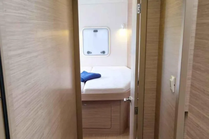  Yacht Photos Pics 2024 Lagoon 42 yacht interior cabin with bed and window view.