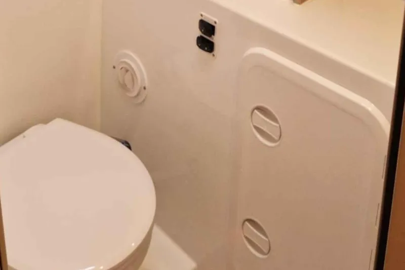  Yacht Photos Pics 2024 Lagoon 42 yacht bathroom with compact toilet and storage compartment.