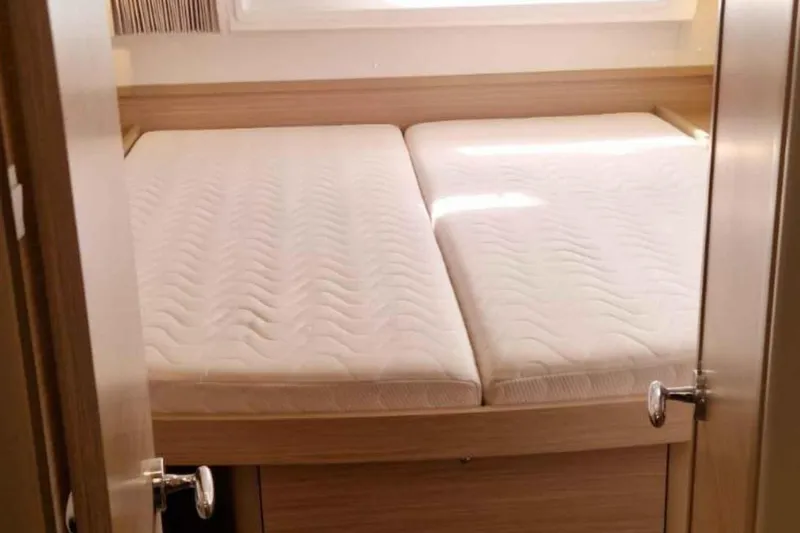  Yacht Photos Pics 2024 Lagoon 42 interior cabin with twin mattresses and wooden finish.