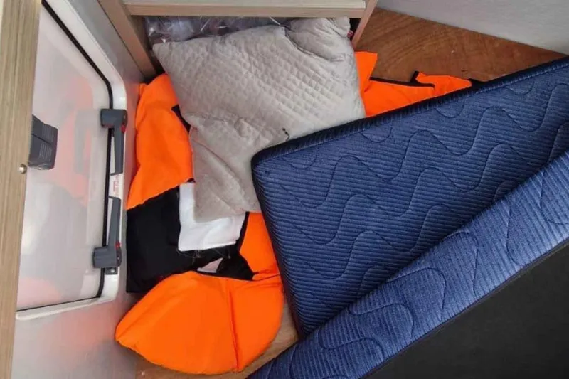  Yacht Photos Pics Storage area in a 2024 Lagoon 42 yacht with life jackets and cushions.