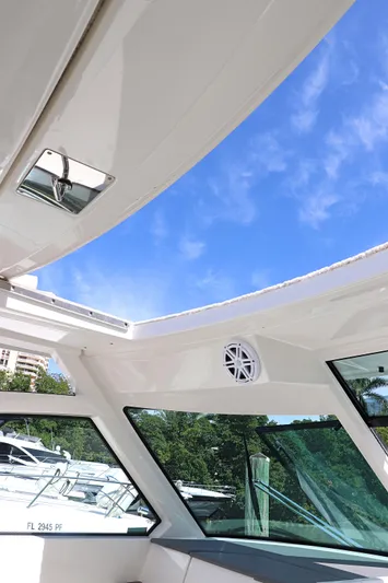  Yacht Photos Pics 2021 Tiara Sport 34 LX boat interior with open roof and clear blue sky.