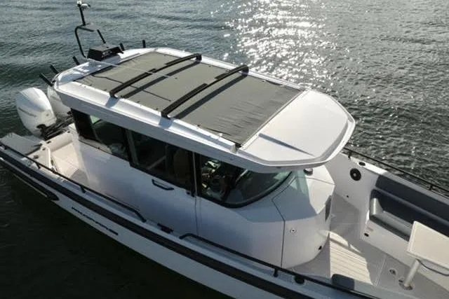 Squirt Yacht Photos Pics 2023 Axopar 28 CABIN boat on water, featuring sleek design and modern cabin.