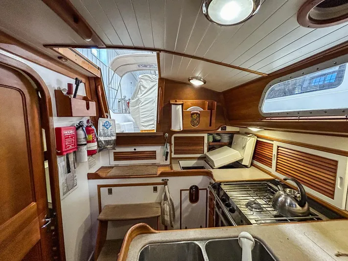 Golden Eye Yacht Photos Pics Hinckley Sou'wester 42 MKII 1996 yacht interior with wooden cabinetry and compact kitchen.