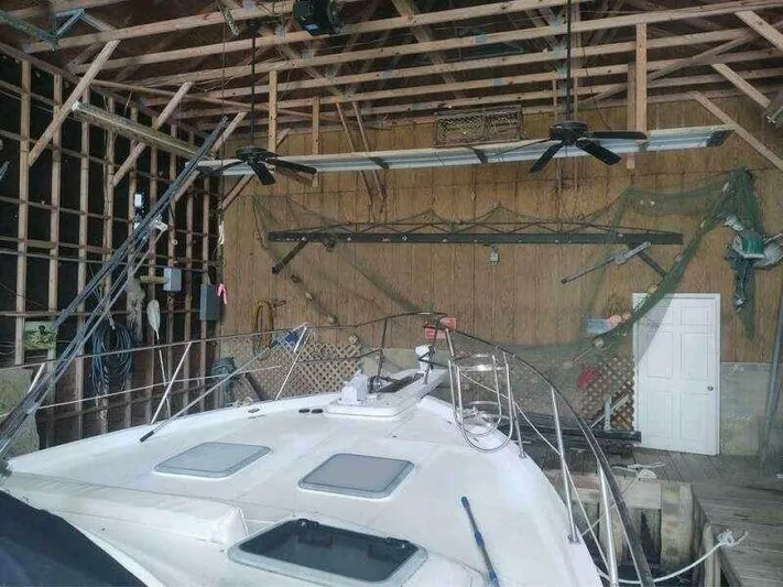  Yacht Photos Pics Bayliner 4788 Pilot House Motoryacht 2000 in a wooden boathouse with fishing nets.