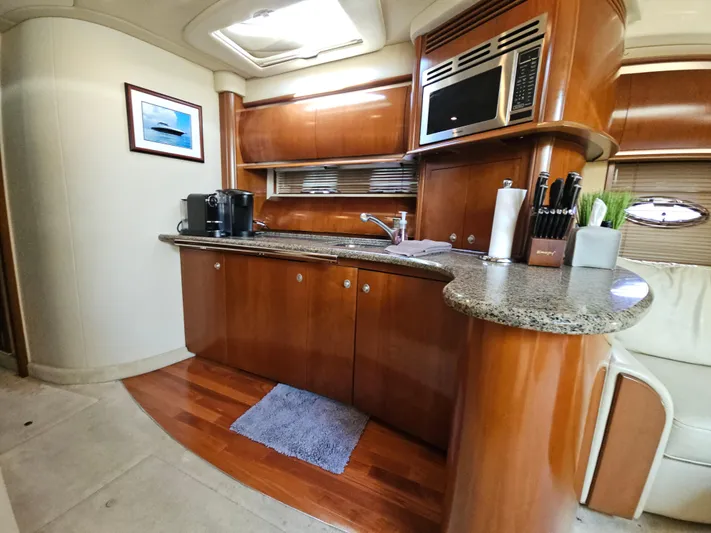 Nautical Dreamer Yacht Photos Pics Luxurious kitchen interior of 2005 Sea Ray 500 Sundancer yacht with wood cabinetry and modern appliances.