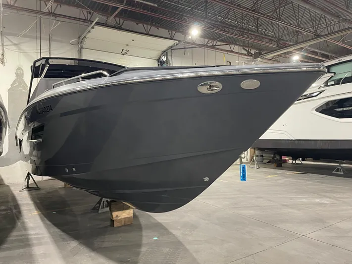  Yacht Photos Pics 2017 Cruisers Yachts 338 SOUTH BEACH in a showroom, sleek black hull design.