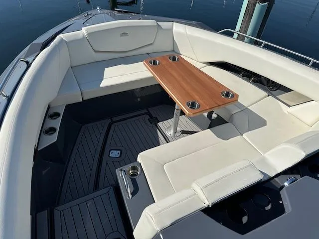  Yacht Photos Pics Luxurious seating area on 2017 Cruisers Yachts 338 SOUTH BEACH with wooden table and cup holders.