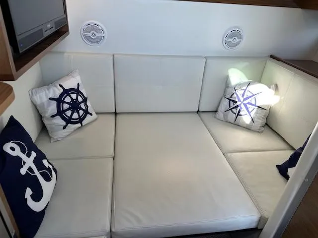  Yacht Photos Pics 2017 Cruisers Yachts 338 SOUTH BEACH interior with nautical-themed cushions on white seating.