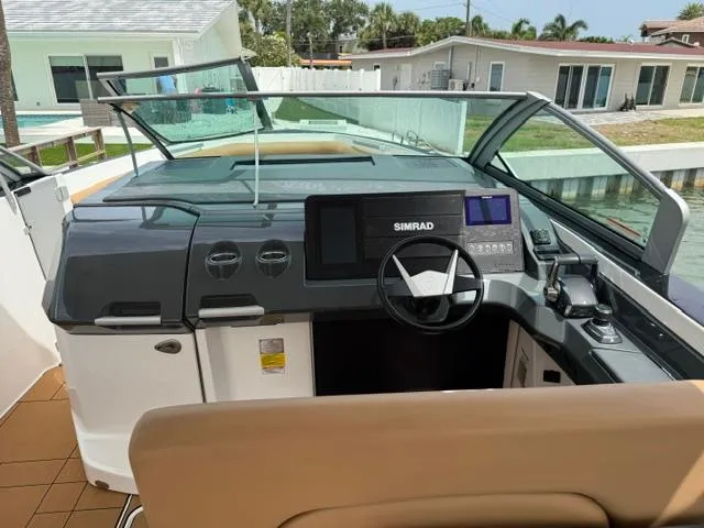  Yacht Photos Pics 2023 Aviara AV36 OB boat cockpit with Simrad navigation system, docked near waterfront homes.