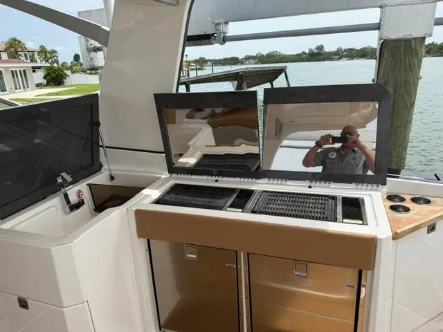  Yacht Photos Pics 2023 Aviara AV36 OB boat interior with grill and storage, docked by a scenic waterfront.