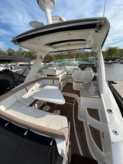  Yacht Photos Pics 2016 Sea Ray 350 Sundancer boat interior with seating and table, docked by the water.