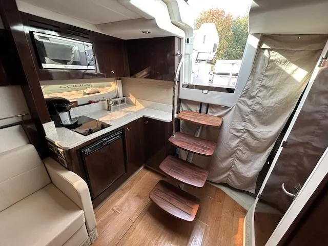  Yacht Photos Pics Interior of 2016 Sea Ray 350 Sundancer yacht with modern kitchen and wooden stairs.