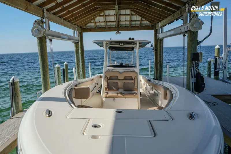  Yacht Photos Pics 2018 Key West Billistic 351 Center Console boat docked under a wooden shelter.