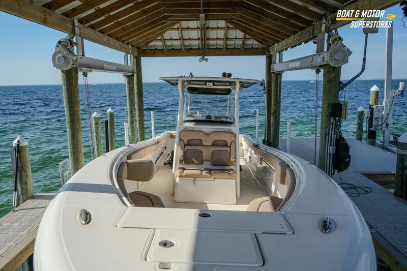 Yacht Photos Pics 2018 Key West Billistic 351 Center Console boat docked under a wooden shelter.