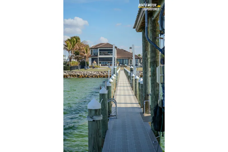  Yacht Photos Pics Dock leading to waterfront property, clear skies, and calm waters. Key West Billistic 351 Center Console, 2018.