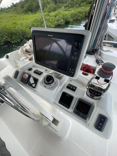 Matilda Mia Yacht Photos Pics Lagoon 52 yacht helm with navigation equipment, 2015 model, surrounded by lush greenery.