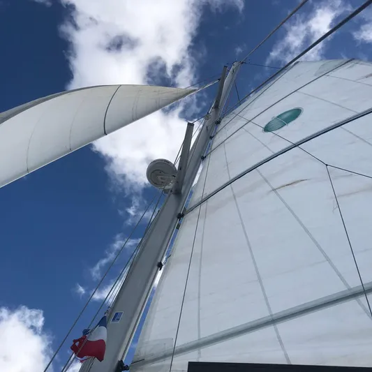Matilda Mia Yacht Photos Pics Sails of a 2015 Lagoon 52 catamaran against a blue sky with clouds.