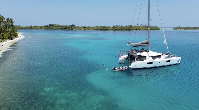 Matilda Mia Yacht Photos Pics Lagoon 52 catamaran anchored in clear blue tropical waters near a sandy beach, 2015 model.
