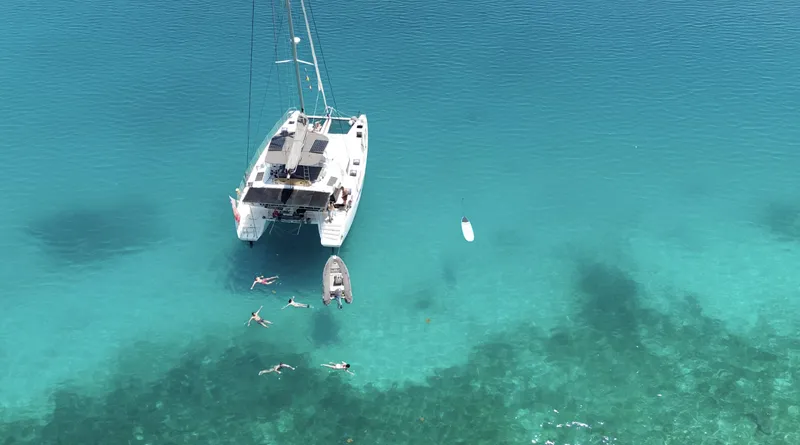 Matilda Mia Yacht Photos Pics Aerial view of 2015 Lagoon 52 catamaran with swimmers in clear turquoise water.