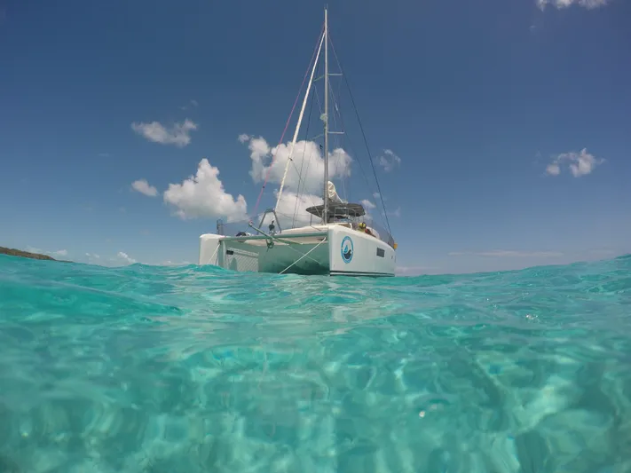 Matilda Mia Yacht Photos Pics Lagoon 52 catamaran sailing in clear turquoise waters under a bright blue sky.