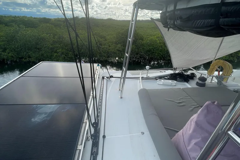 Matilda Mia Yacht Photos Pics 2015 Lagoon 52 yacht deck with solar panels and seating, surrounded by lush greenery.