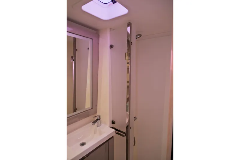 Ruckus Yacht Photos Pics Bathroom interior of 2021 Fountaine Pajot Elba 45 Catamaran, featuring modern sink and mirror.