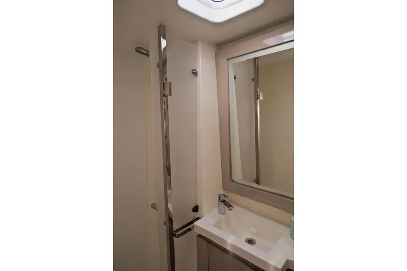 Ruckus Yacht Photos Pics Bathroom interior of 2021 Fountaine Pajot Elba 45 Catamaran with sink and mirror.