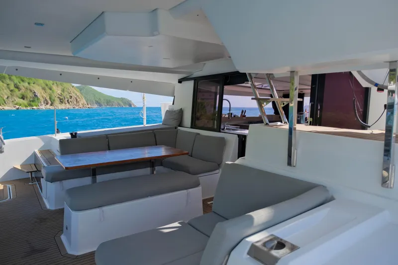 Ruckus Yacht Photos Pics 2021 Fountaine Pajot Elba 45 Catamaran interior with seating, table, and ocean view.
