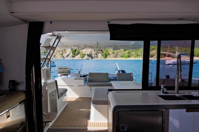 Ruckus Yacht Photos Pics Interior view of 2021 Fountaine Pajot Elba 45 Catamaran with ocean and island backdrop.