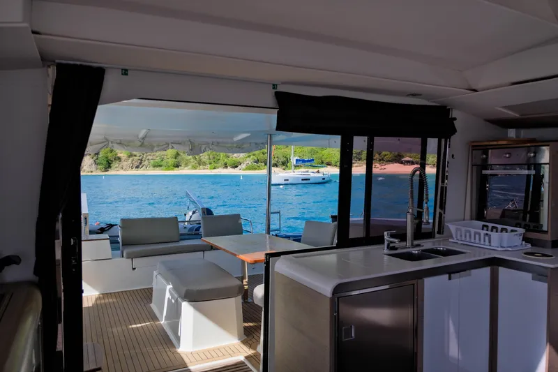 Ruckus Yacht Photos Pics Interior view of 2021 Fountaine Pajot Elba 45 Catamaran with ocean and island backdrop.