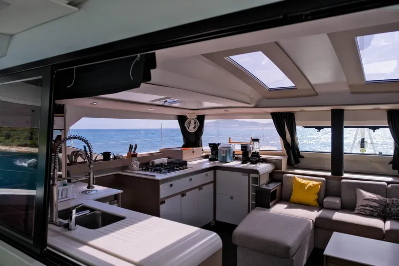 Ruckus Yacht Photos Pics Interior of 2021 Fountaine Pajot Elba 45 Catamaran with modern kitchen and ocean view.