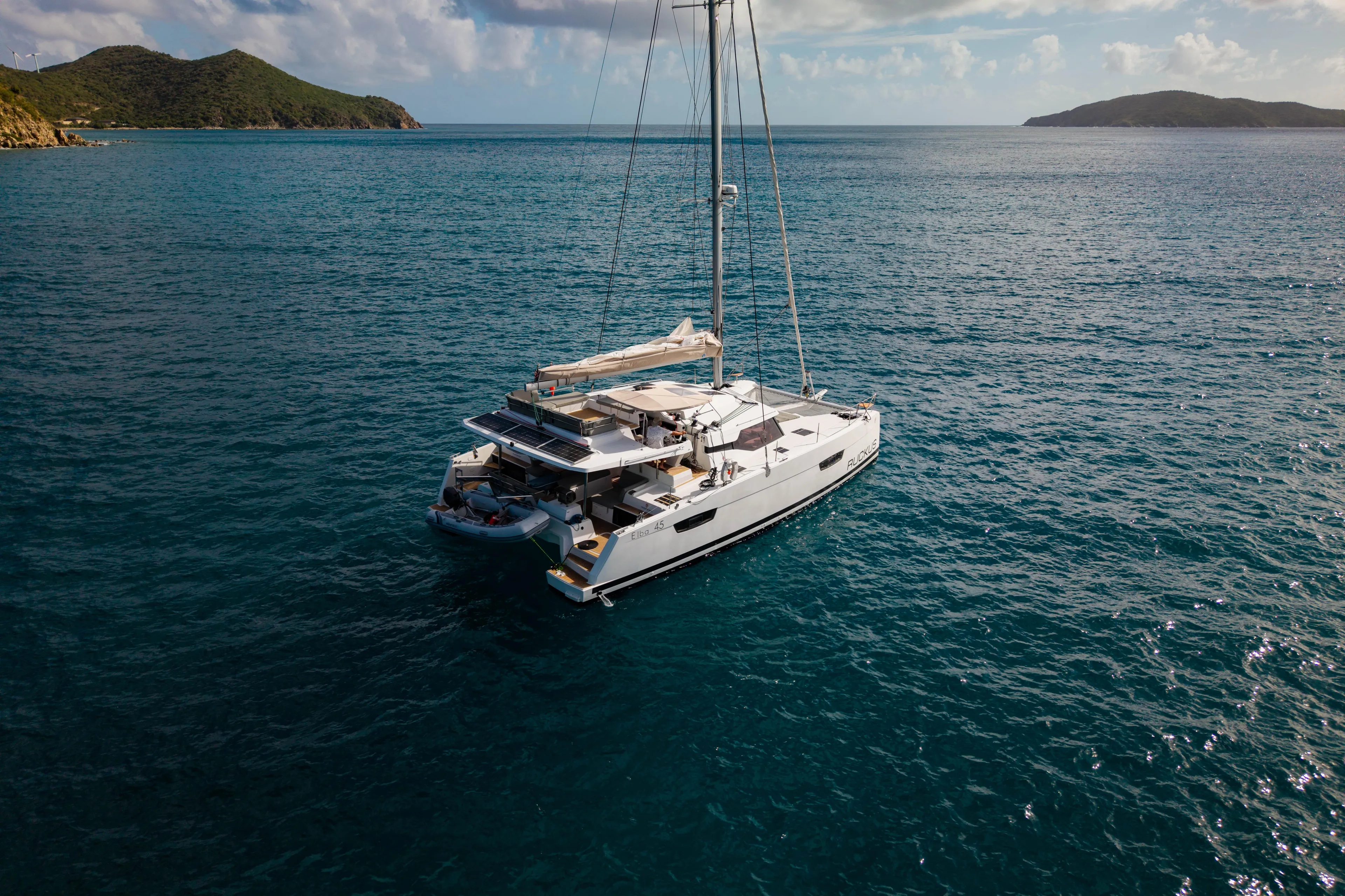 Ruckus Yacht Photos Pics 2021 Fountaine Pajot Elba 45 Catamaran sailing in serene ocean waters.