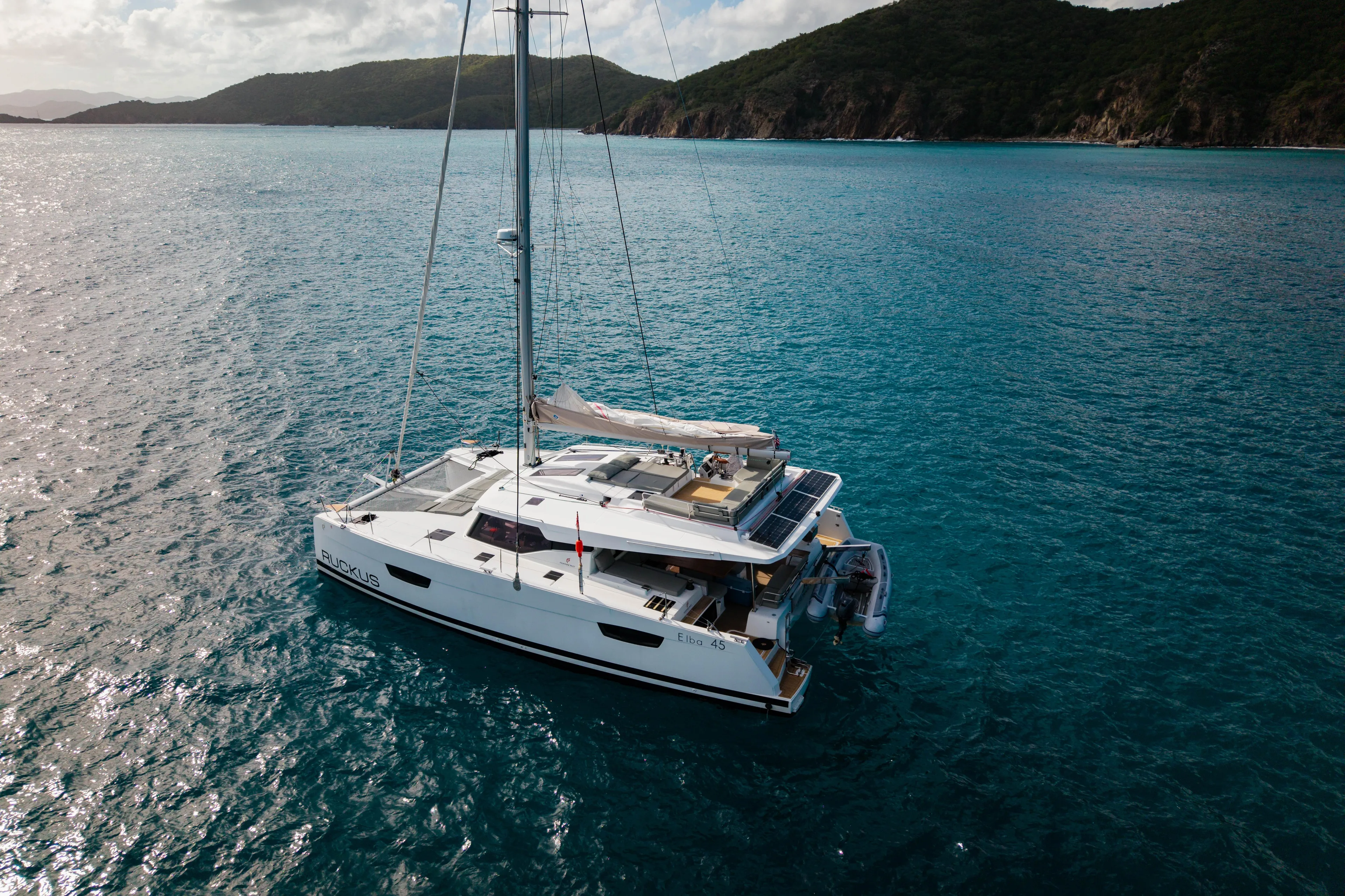Ruckus Yacht Photos Pics 2021 Fountaine Pajot Elba 45 Catamaran sailing in clear blue waters.
