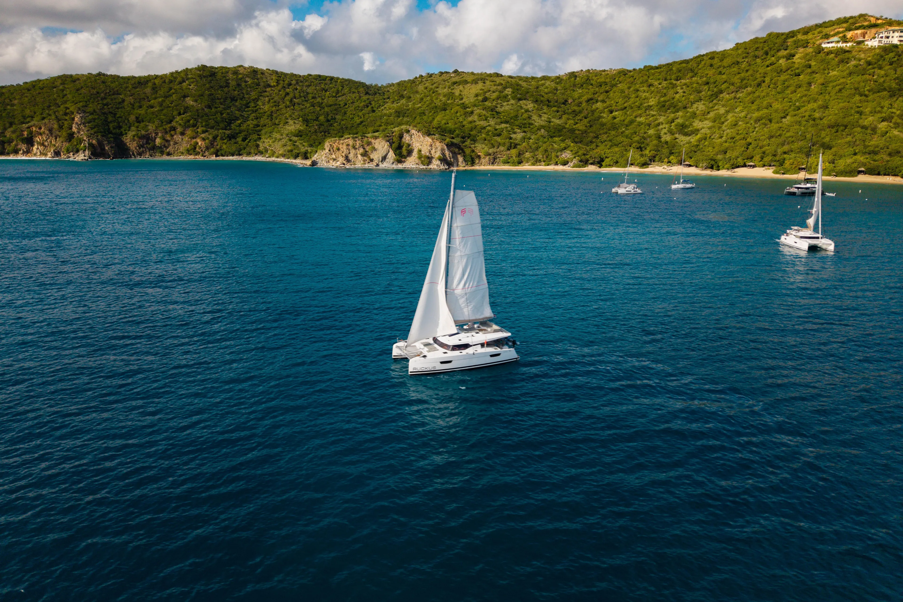 Ruckus Yacht Photos Pics 2021 Fountaine Pajot Elba 45 Catamaran sailing in scenic coastal waters.