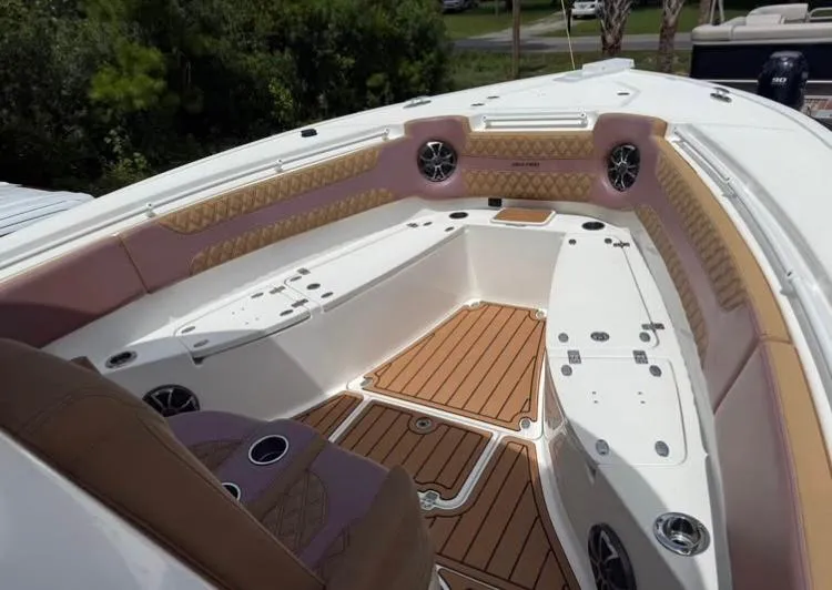  Yacht Photos Pics 2022 Sea Pro 320 DLX Offshore boat interior with cushioned seating and teak flooring.