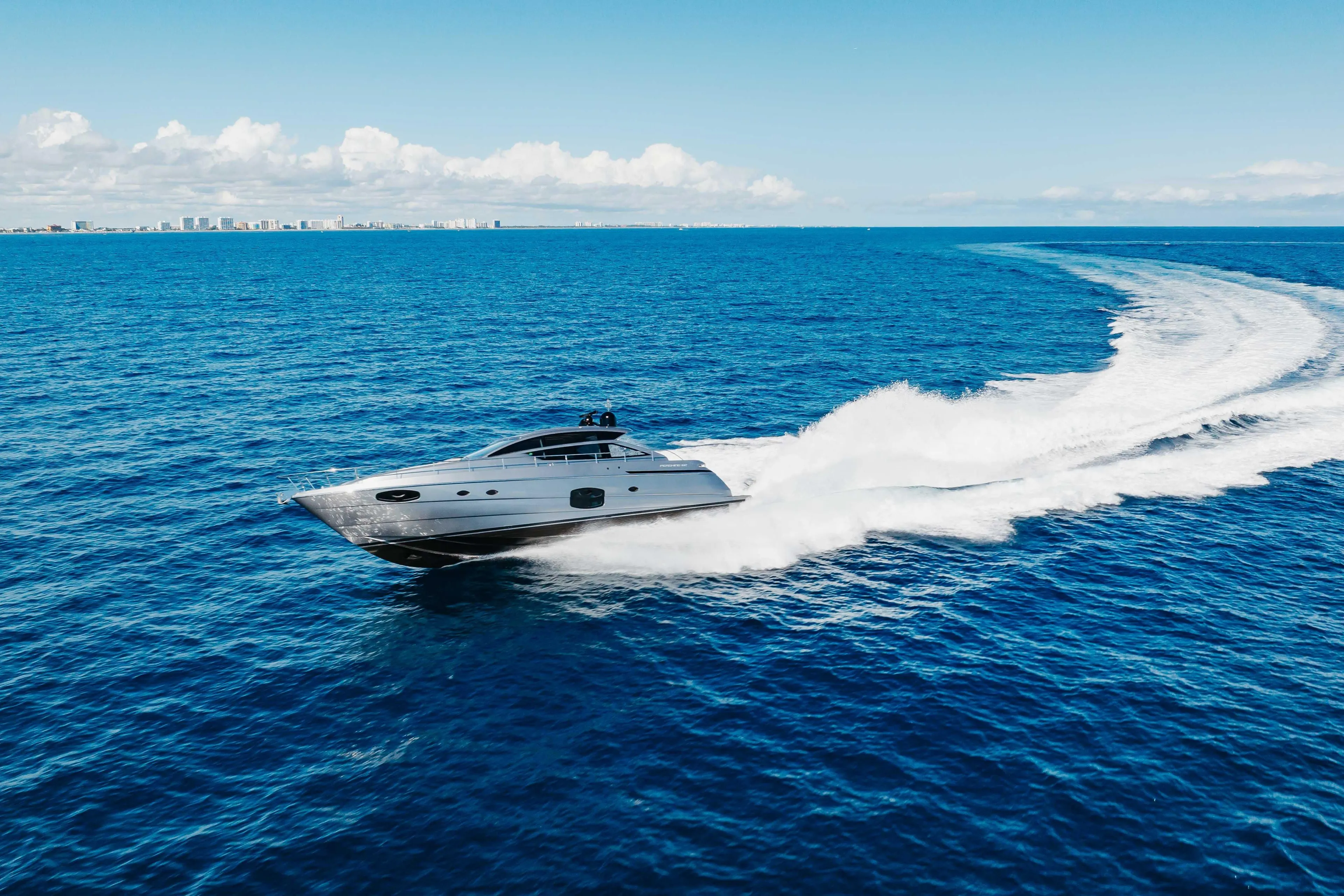 2016 Pershing 62 yacht cruising on open blue ocean under clear sky.