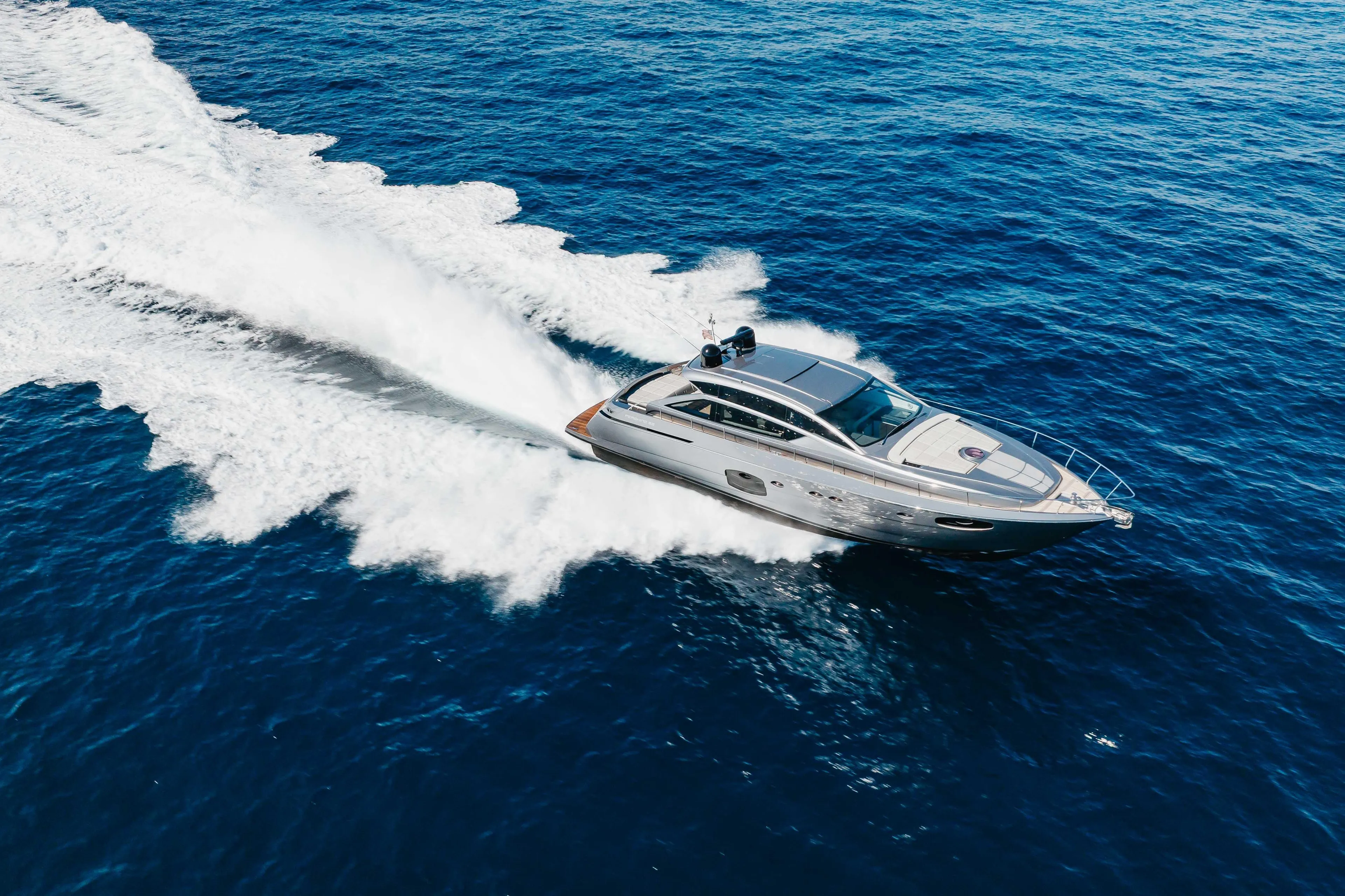2016 Pershing 62 yacht cruising on open blue sea, creating a dynamic wake.