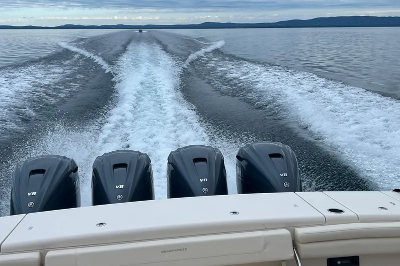  Yacht Photos Pics 2023 Grady-White Canyon 456 boat with four V8 engines cruising on a calm lake.